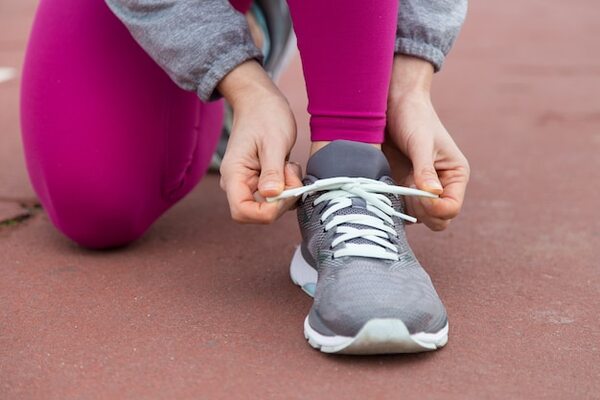 کفش دخترانه اسپرت | راهنمای کامل خرید، انتخاب سایز و نگهداری ۲۰۲۶ 3 close up runner tying lace sport shoe 1262 18410 ezgif.com resize min 1